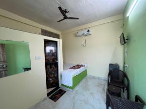 a small room with a bed and a ceiling fan at HOTEL o GUMTHI STAY INN in Patansaongi