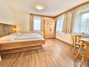 a bedroom with a bed and a table and chairs at Ferienwohnungen Christine in Waidring