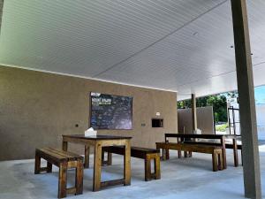 a group of tables and benches in a room at Jou Trekking Guesthouse in Senaru
