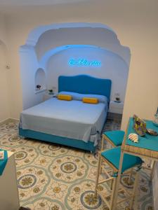 a bedroom with a blue bed and a chair at La Piccola Suite in Anacapri