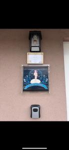 a picture on a wall with a clock on it at Venus Casa in Solt