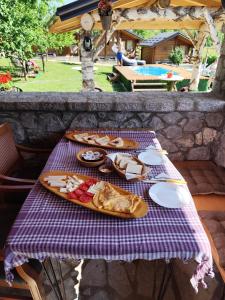 a picnic table with a plate of food on it at SkyFrame cottage with pool in Plav