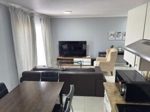 a living room with a couch and a tv at Blouberg Beach Gem 5 Min Walk in Cape Town