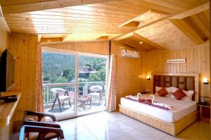 a bedroom with a bed and a balcony at Royal Nest in Kasauli