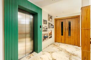 a green wall in a hallway with a door at Meadows Residency in Ooty