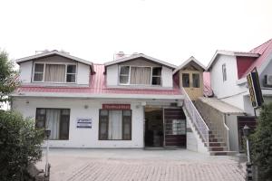 a white building with a stairway in front of it at Royal Nest in Kasauli