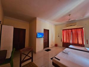 a bedroom with a bed and a tv on the wall at PTC Residency in Alleppey