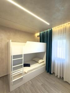 a white bunk bed in a room with a window at Apart-Hotel Suites - Qerret, Golem, Durres in Golem +24 photos