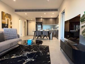 a living room with a couch and a table at Luxurious City View with Gym Pool Parking Playground in Sydney +19 photos