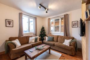 a living room with a couch and a christmas tree at Chalet Firefly in Bansko