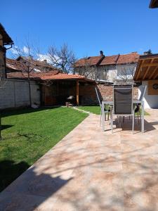a patio with two chairs in a yard at Chalet Firefly in Bansko
