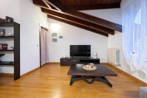 a living room with a coffee table and a tv at L'Archè - The Rustic Loft in Cinisello Balsamo