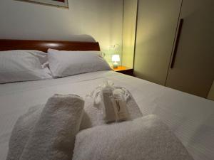 a bed with towels and a candle on it at L'Archè - The Rustic Loft in Cinisello Balsamo