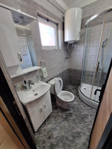 a bathroom with a toilet and a sink and a shower at Goka apartments in Gevgelija