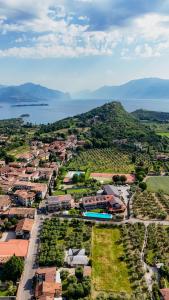 Luftaufnahme einer Stadt mit Wasser und Bergen in der Unterkunft Spa Hotel Splendid Sole in Manerba del Garda