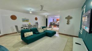 a living room with a green couch and a kitchen at Mtwapa Beach Nest D3 in Mtwapa