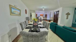 a dining room with a table and a blue couch at Mtwapa Beach Nest D3 in Mtwapa