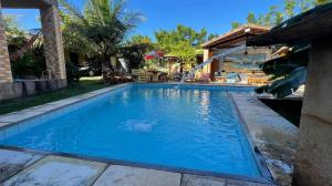 a large blue swimming pool with a slide in a yard at Châle guesthouse in Paracuru +36 photos