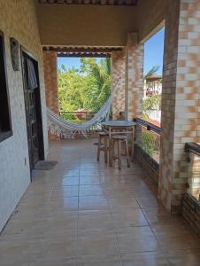 a patio with a table and chairs and a hammock at Châle guesthouse in Paracuru