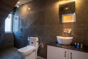 a bathroom with a toilet and a sink at Royal Nest in Kasauli