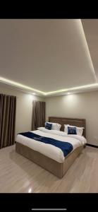 a bedroom with a large bed with blue and white pillows at Seven sky hotel in Murree