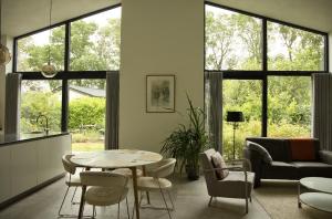 a living room with a table and chairs at Luxe recreatiebungalows midden in bosrijke omgeving Waalre Noord-Brabant in Waalre