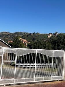 a white fence with a view of a field at Abijah Ridgeview Studios in Roodepoort