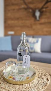 a bottle and two glasses on a plate on a table at Bergkristall B&B in Berwang
