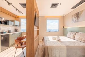 a small bedroom with a bed and a kitchen at Flat Premium Design Moderno, Completo in Osasco