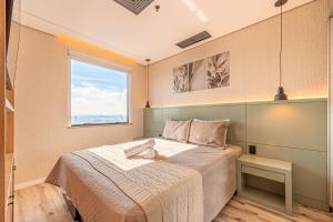 a bedroom with a large bed and a window at Flat Premium Design Moderno, Completo in Osasco +74 photos