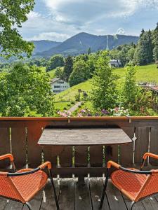 two chairs and a table on a deck with a view at Landhaus Schönblick in Bad Kohlgrub