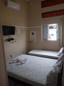 a small bedroom with a bed and a window at Casa de hospedagem in Aparecida