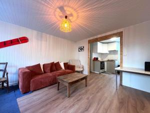a living room with a red couch and a table at Maison CALI LUZ in Luz-Saint-Sauveur