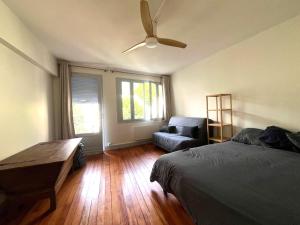 a bedroom with a bed and a couch and a ceiling fan at Maison CALI LUZ in Luz-Saint-Sauveur