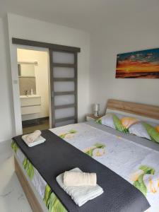 two beds in a room with towels and a mirror at Apartments Luka in Rab +27 photos