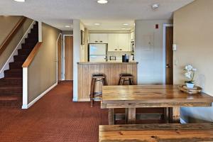 a living room with a wooden table and a kitchen at Mountainview Condo at Rivergreen in Lincoln