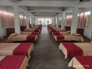 a row of beds in a large room at Adharshila hotel & Dormitory in Shahdol