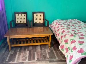 a room with a table and a bed in a room at The Soul Himalaya in Tosh