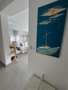 a living room with a painting of a boat on the wall at Chambre d'hôtes in Montauban +8 photos