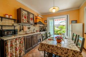 a kitchen with a table with chairs and a refrigerator at Appartamento Caretto in Baveno