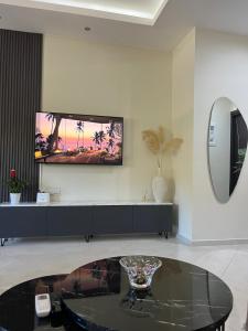 a living room with a table and a tv on the wall at Amare casa in Perivólia