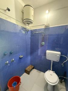 a blue tiled bathroom with a toilet and a shower at The Soul Himalaya in Tosh