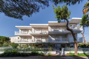 an apartment building with balconies and a tree at PJ Properties Riviera Escape Suite Sounio in Sounio
