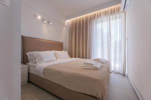a bedroom with a bed with towels on it at PJ Properties Riviera Escape Suite Sounio in Sounio