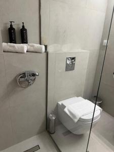 a bathroom with a toilet and a glass shower door at PJ Properties Riviera Escape Suite Sounio in Sounio +17 photos