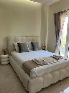 a large bed in a room with a large window at Amare casa in Perivólia