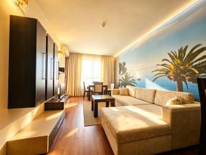 a living room with a couch and a tv at Europroperties Zlatna Kotva Apartments in Golden Sands