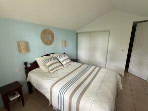 a bedroom with a large bed with a striped blanket at Superbe appartement 6 personnes in Biscarrosse +23 photos
