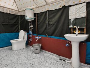 a bathroom with a sink and a toilet in a tent at GUREZ LUXURY Resort by GRITTI CASTLE in Wāmpor