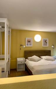 two beds in a room with yellow walls at Apartments Olga in Bled